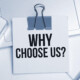 paper clip holding small note with why choose us in large print